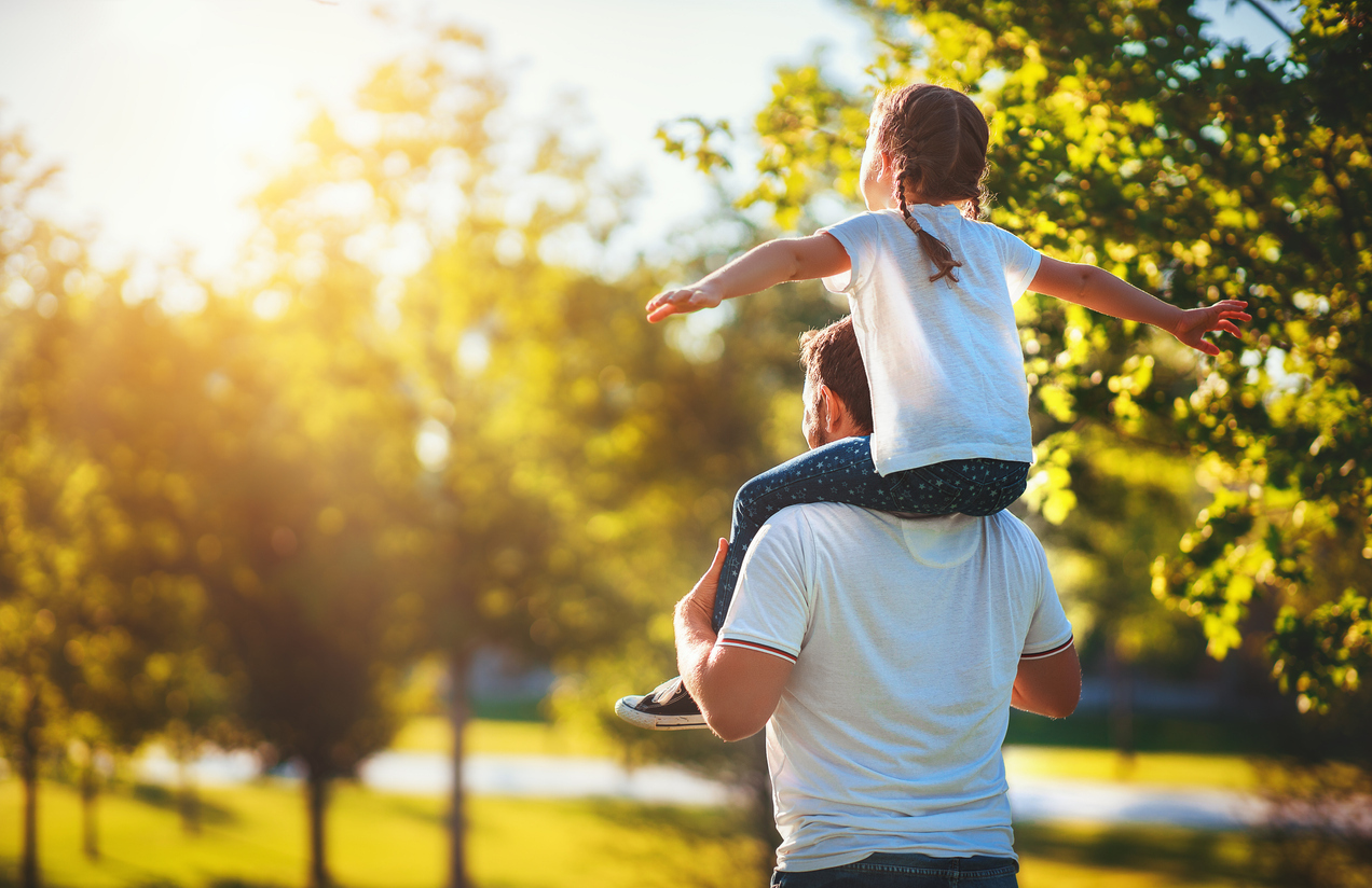 Child riding on adult's shoulders